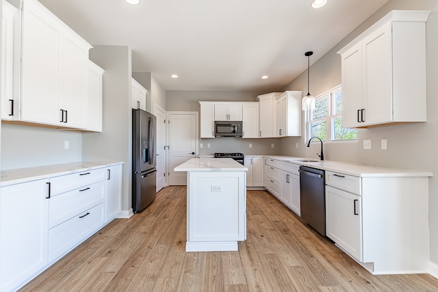 kitchen with light hardwood / wood-style flooring, a center island, appliances with stainless steel finishes, and hanging light fixtures