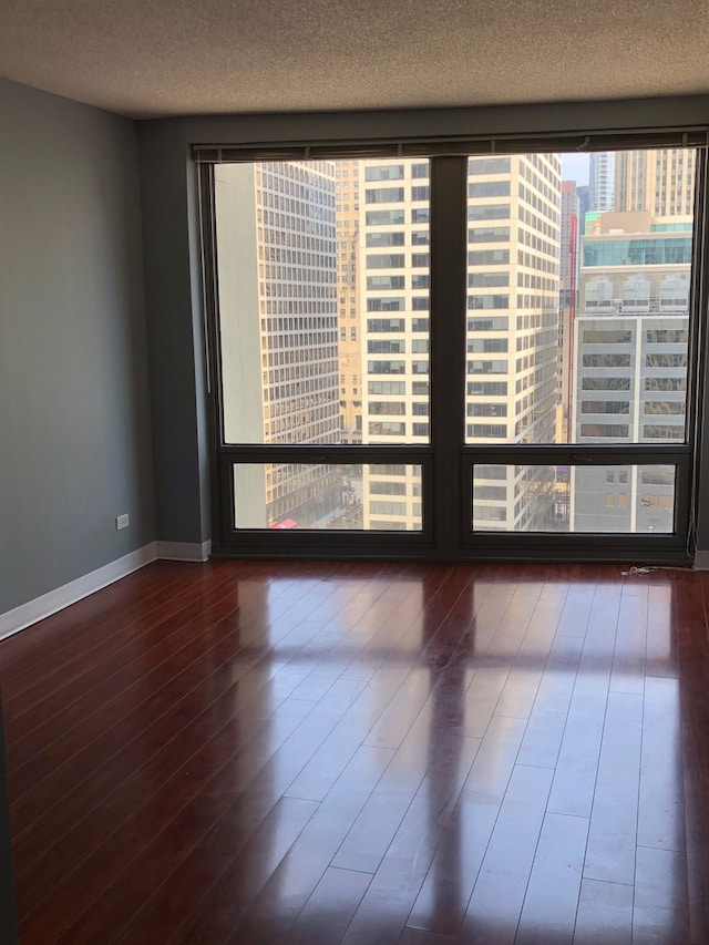 empty room featuring dark hardwood / wood-style flooring and a textured ceiling