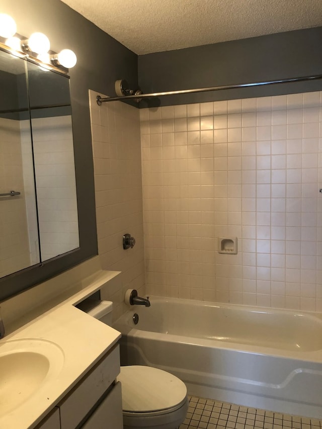 full bathroom featuring a textured ceiling, tiled shower / bath, tile floors, large vanity, and toilet