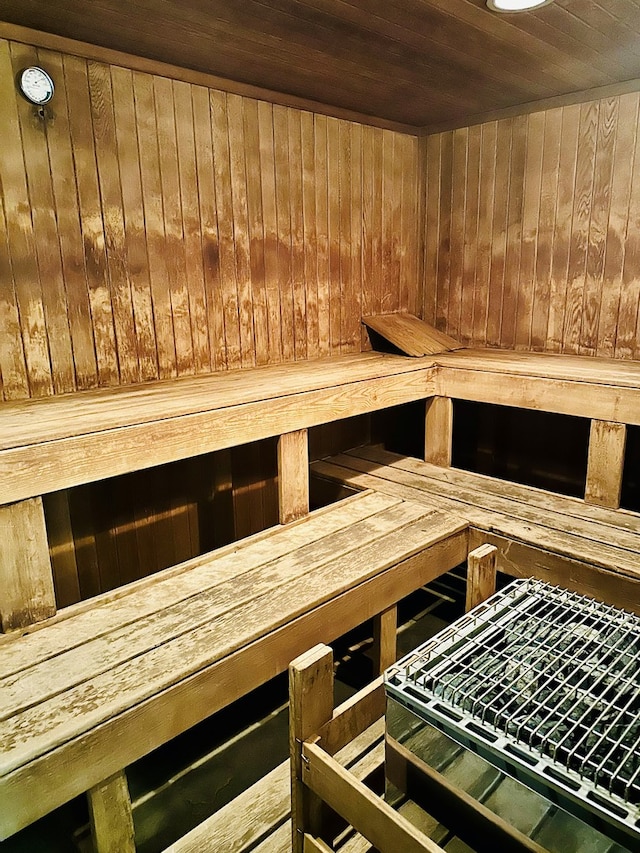 view of sauna / steam room featuring wooden ceiling and wooden walls