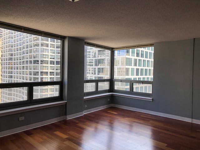 empty room featuring dark wood-type flooring and a textured ceiling