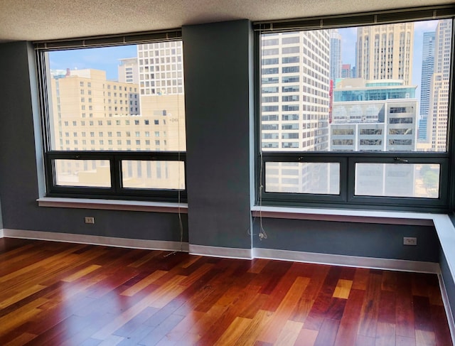 empty room featuring dark hardwood / wood-style flooring and a textured ceiling