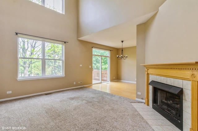 211 Grand Ridge Rd, Saint Charles, IL 60175 - unfurnished living room with a chandelier, light colored carpet, a towering ceiling, a fireplace, and baseboards