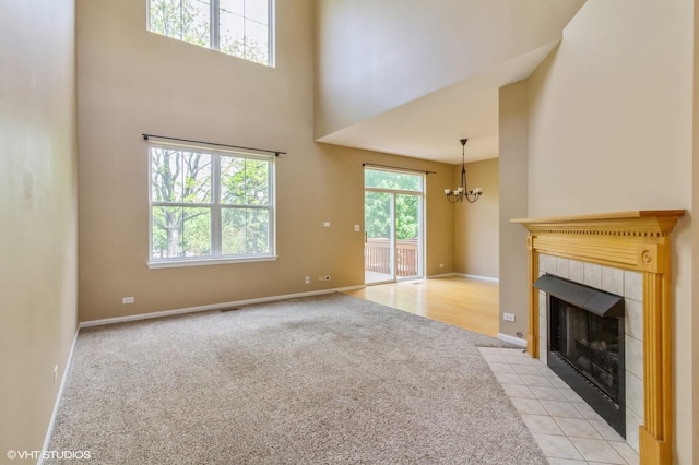 211 Grand Ridge Rd, Saint Charles, IL 60175 - unfurnished living room with light colored carpet, a chandelier, a towering ceiling, a fireplace, and baseboards