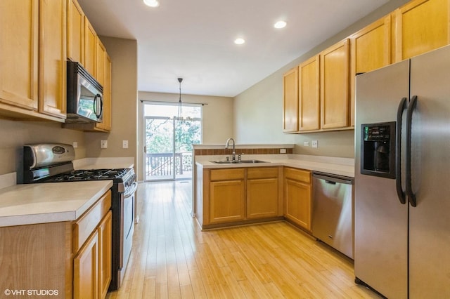 211 Grand Ridge Rd, Saint Charles, IL 60175 - kitchen with stainless steel appliances, a sink, a peninsula, light countertops, and light wood finished floors