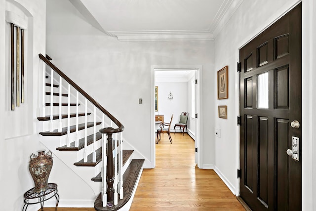 foyer with crown molding and light hardwood / wood-style flooring