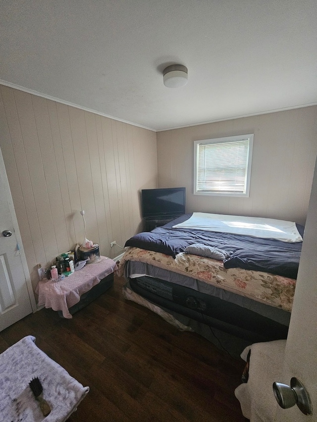 bedroom featuring ornamental molding and dark hardwood / wood-style floors