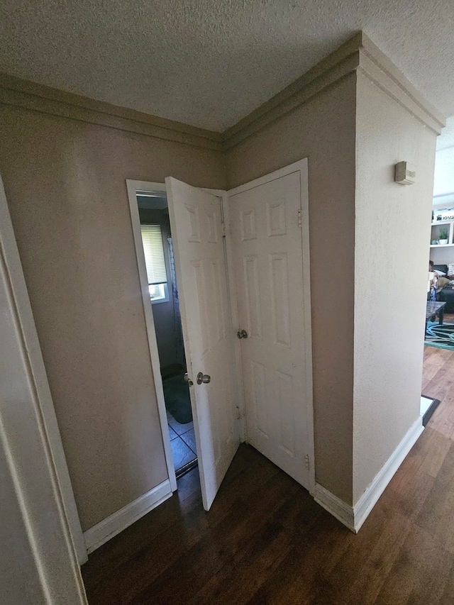 hallway featuring dark hardwood / wood-style flooring and a textured ceiling