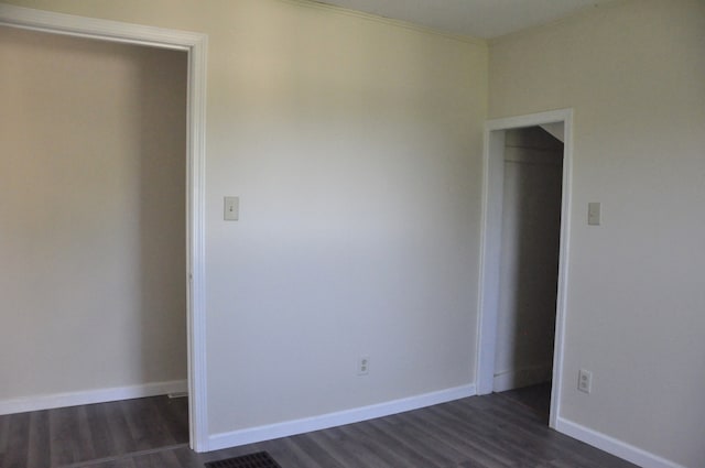 unfurnished bedroom featuring dark wood-type flooring and a closet