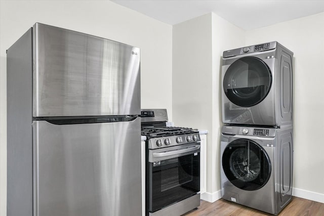 washroom featuring hardwood / wood-style floors and stacked washer / drying machine