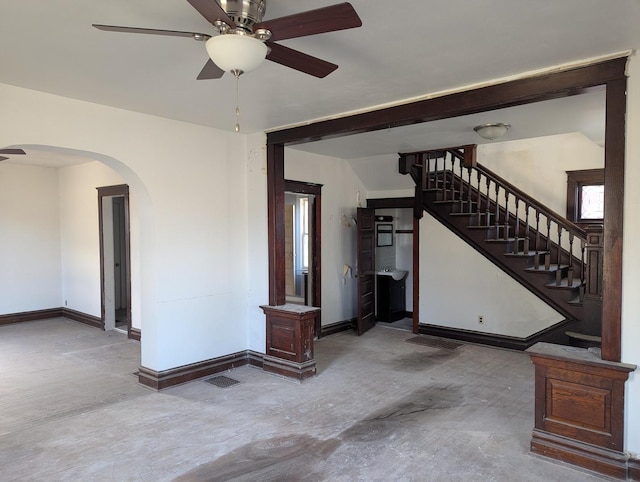 unfurnished living room featuring ceiling fan and concrete flooring