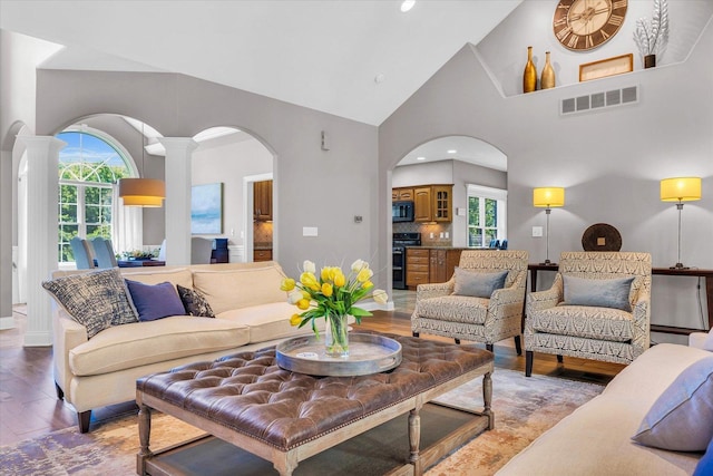 living room with light wood-style flooring, visible vents, and a healthy amount of sunlight