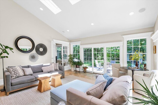 living room with high vaulted ceiling, a skylight, and recessed lighting