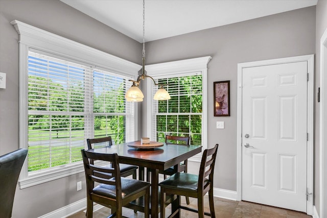 dining room with a healthy amount of sunlight, baseboards, and an inviting chandelier