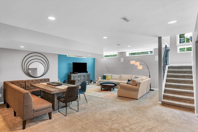 living area with light carpet, visible vents, stairway, and recessed lighting