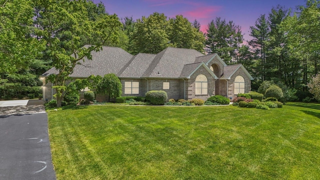 view of front of house with a front yard and roof with shingles