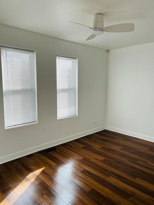 empty room with dark wood-type flooring and ceiling fan