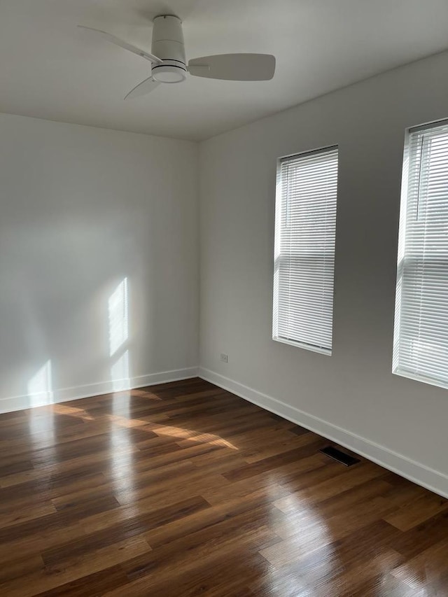 unfurnished room featuring dark wood-type flooring and ceiling fan