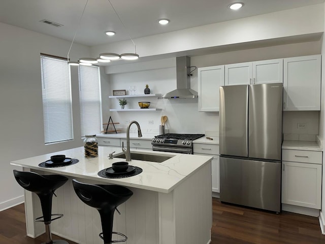 kitchen featuring white cabinetry, appliances with stainless steel finishes, dark hardwood / wood-style flooring, and wall chimney range hood