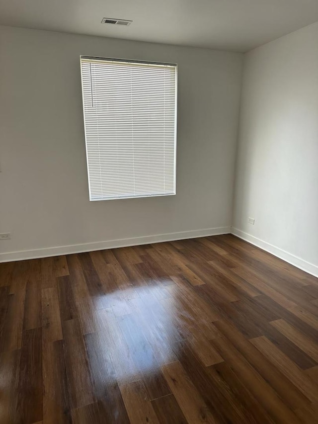 spare room with dark hardwood / wood-style flooring