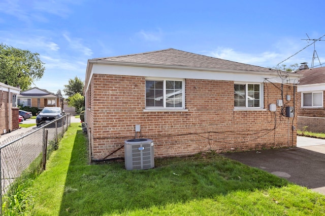 view of property exterior with central AC unit and a lawn