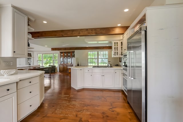 kitchen featuring appliances with stainless steel finishes, white cabinets, dark hardwood / wood-style flooring, and a wealth of natural light