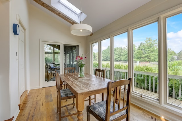 sunroom / solarium featuring vaulted ceiling with skylight