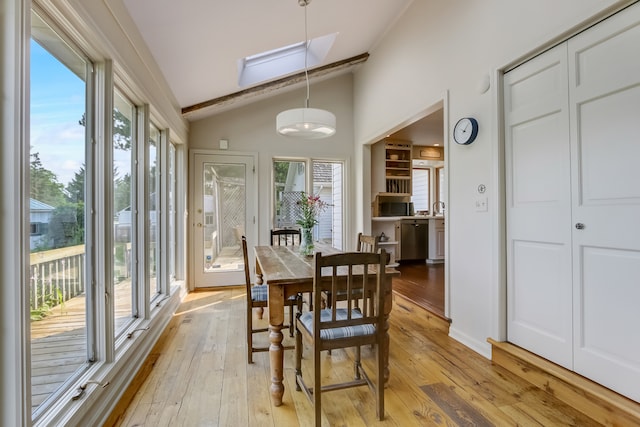 interior space featuring light wood-type flooring, lofted ceiling with skylight, and plenty of natural light