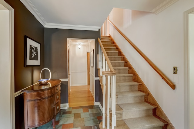 staircase featuring hardwood / wood-style floors and ornamental molding