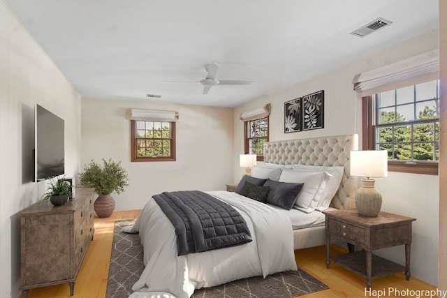 bedroom featuring light wood-type flooring, multiple windows, and ceiling fan