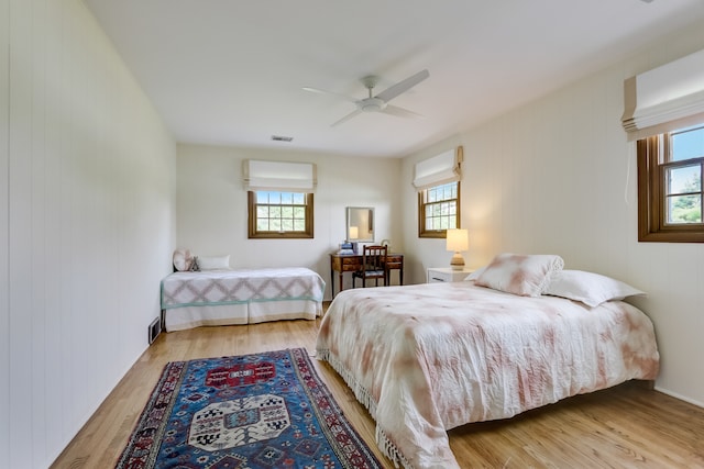 bedroom with multiple windows, light wood-type flooring, and ceiling fan