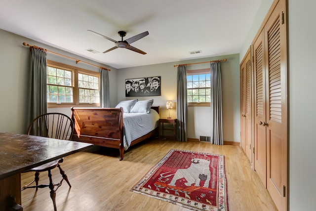 bedroom featuring ceiling fan, light wood-type flooring, and multiple windows