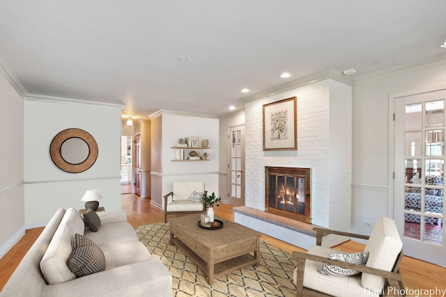 living room featuring a healthy amount of sunlight, light hardwood / wood-style flooring, and a brick fireplace