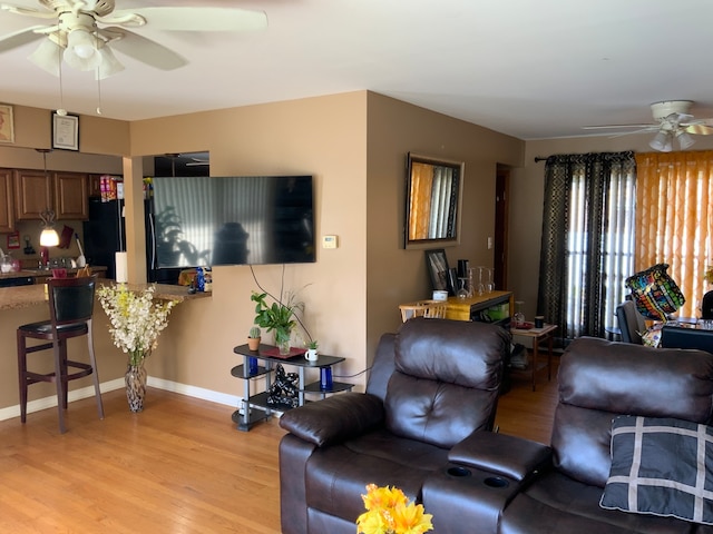 living room featuring ceiling fan and light hardwood / wood-style flooring