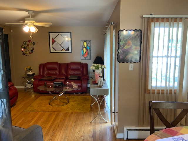 living room with ceiling fan, a wealth of natural light, and wood-type flooring