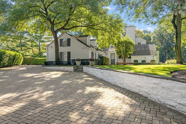 view of front of home featuring a front yard and a chimney