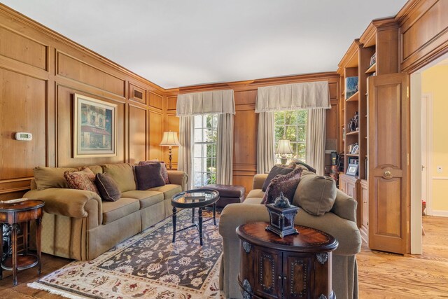 living room with ornamental molding and light hardwood / wood-style flooring