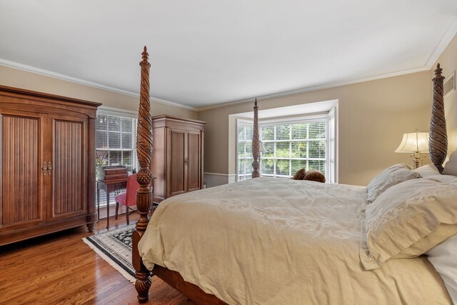 bedroom with ornamental molding and dark wood-type flooring