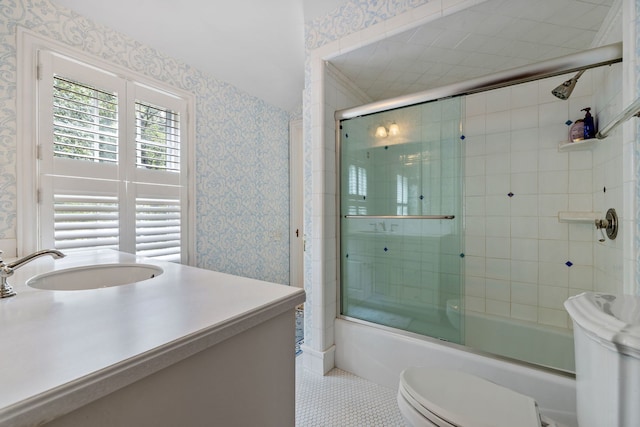 bathroom with combined bath / shower with glass door, tile patterned floors, toilet, and wallpapered walls