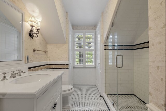 bathroom with tile flooring, tile walls, walk in shower, toilet, and large vanity