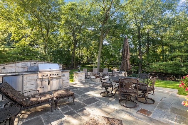 view of patio / terrace featuring exterior kitchen, an outdoor fire pit, area for grilling, and outdoor dining space