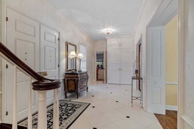 foyer with stairway, baseboards, and ornamental molding