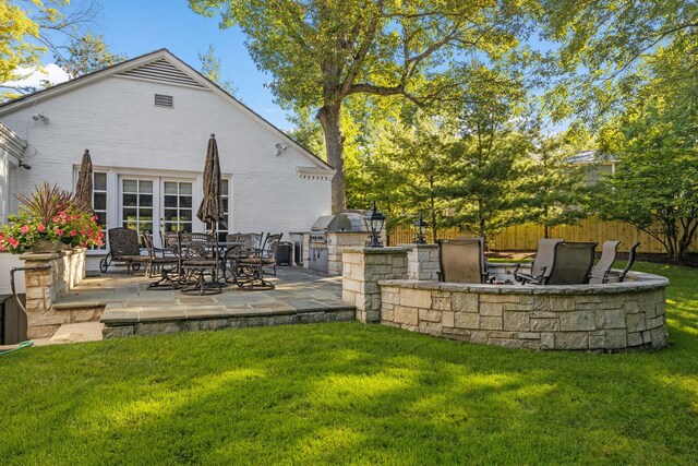 back of house featuring a patio area, exterior kitchen, and a yard