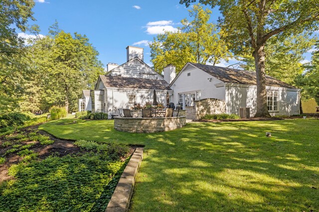 rear view of property with a lawn and a patio area