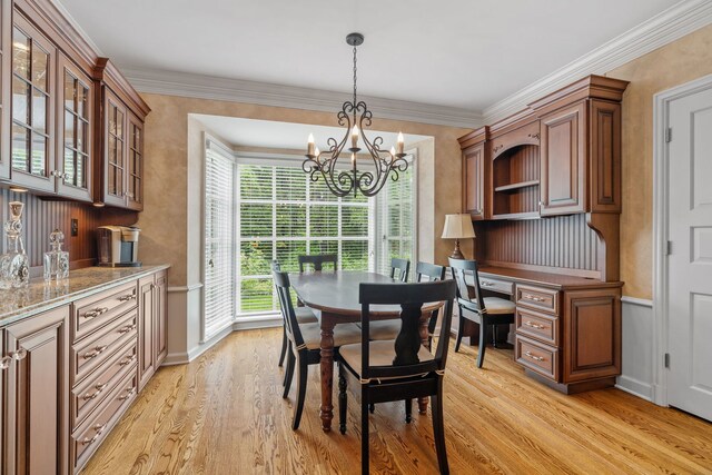 dining area featuring a notable chandelier, light hardwood / wood-style flooring, and crown molding