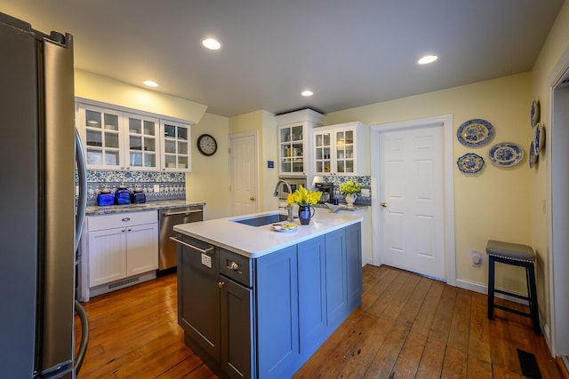 kitchen with white cabinets, backsplash, sink, and appliances with stainless steel finishes