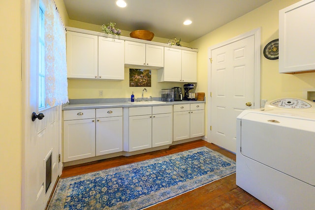 laundry room with dark hardwood / wood-style floors, cabinets, sink, and washer / clothes dryer