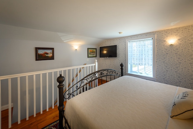 bedroom with hardwood / wood-style floors and lofted ceiling