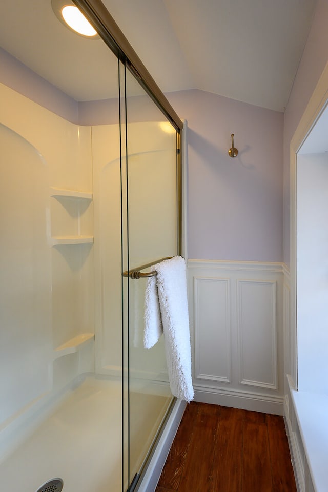 bathroom with hardwood / wood-style floors and a shower with shower door