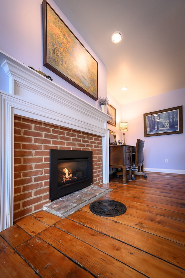 unfurnished living room featuring wood-type flooring and a fireplace